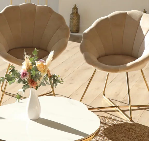Two shell chairs and a flower arrangement on a coffee table