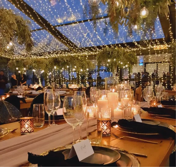Candlelit reception beneath hanging greenery and lights