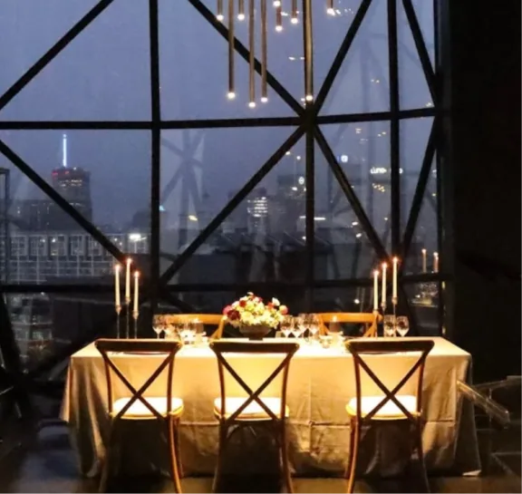 Candlelit dinner table in front of a city view